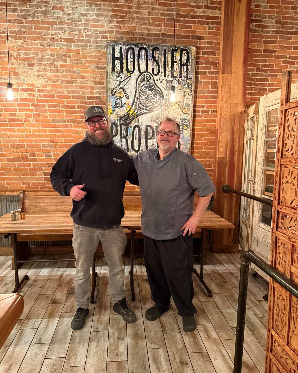 Owner and chef in front of Hoosier Proper mural