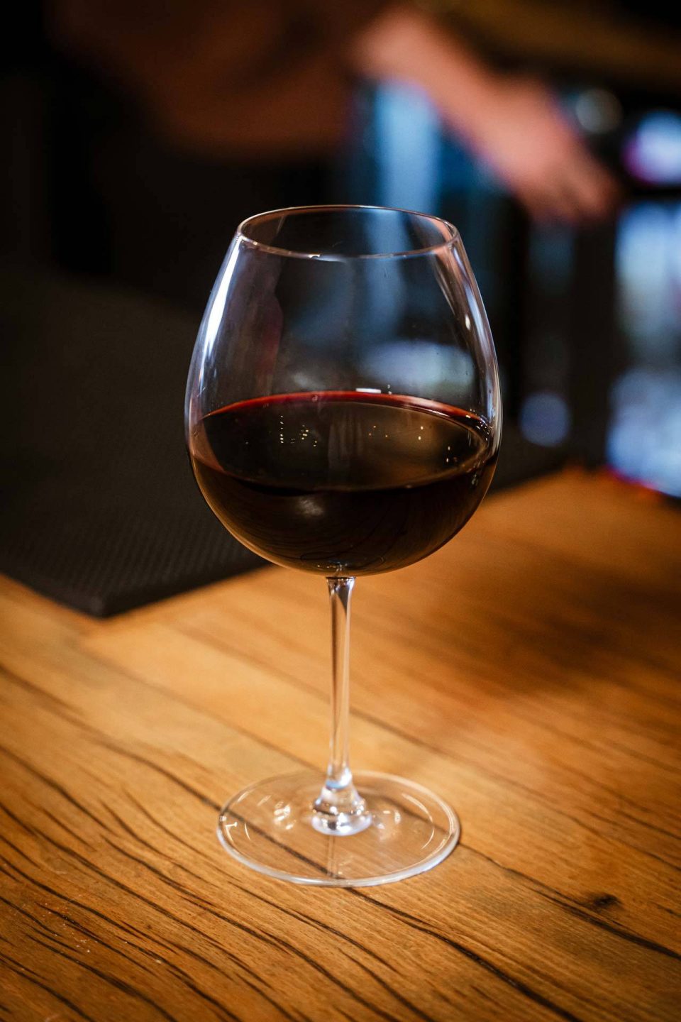 Glass of red wine on the reclaimed wood bar