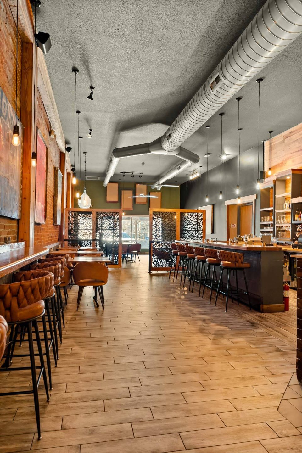 Long view of the dining room and bar with reclaimed wood floors