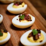 Deviled eggs topped with bacon and microgreens