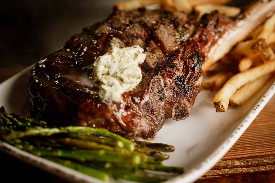 Bone-in ribeye with herb butter, fries, and asparagus